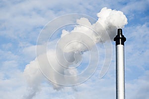 Flue chimney and smoke against blue sky