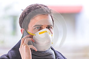 Flue and corona safety concept. Business man wearing face mask to protect himself and using smartphone. Outdoors