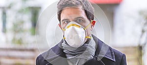 Flue and corona safety concept. Man wearing face mask to protect himself, outdoors