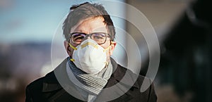 Flue and corona safety concept. Man wearing face mask to protect himself, outdoors