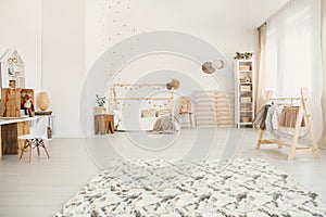 Fluffy carpet in white kid bedroom interior with house-shaped be