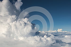 Fluffy clouds Cumulonimbus at high altitude over deep blue sky. Heaven, freedom, purity concept.