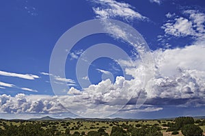 Fluffy clouds dance over the southwest landscape of north central New Mexico after a recent rain shower photo