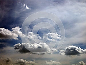 Fluffy clouds drift along a graying blue sky