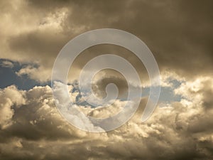 Fluffy clouds over sunset sky. Fluffy cumulus cloud shape photo, gloomy cloudscape background, smoke in the sky