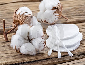 Fluffy cotton ball and cotton swabs and pads on wood. photo