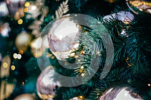 Fluffy fir decorated with gold bauble close up. Christmas and new year background with bokeh and copy space