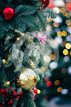 Fluffy fir decorated with gold and red baubles. lights