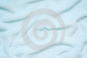 Fluffy Gentle baby blue fabric. Soft pastel textile texture. Folds on the soft fabric. Blue towel terry cloth