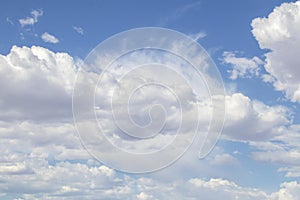 Fluffy and whispy clouds almost cover pretty blue sky