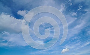 Fluffy white big clouds in deep blue sky in summer