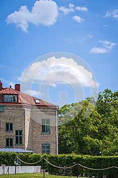 Fluffy white clouds on blue sky above historic building and park in Lund Sweden in summer