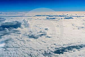 Fluffy white clouds and blue sky from airplane