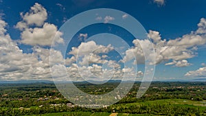 Fluffy white clouds in the blue sky over the green jungle.