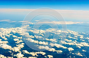 Fluffy white clouds and blue sky seen from airplane.