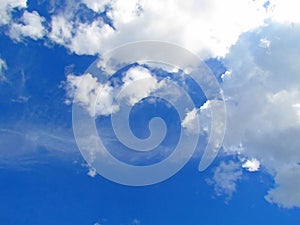 Fluffy white clouds clumped together against the blue sky