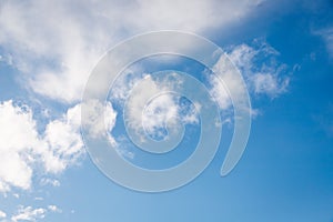 Fluffy white small clouds on the clear blue color sky background