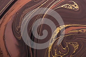 Fluid Art. Abstract Golden curl and lines on brown waves. Marbling background or texture