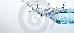 Fluid water with splashing droplets against a white backdrop. Wide banner. Copy space. Concept of hydration, purity