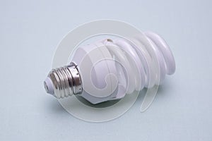 A fluorescent light bulb on a green background. New lightbulb