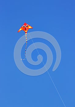 A Fluro Colored Kite against a bright blue summer sky