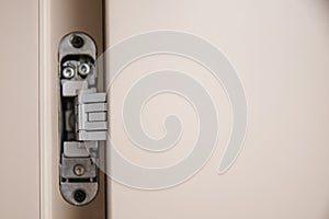 Flush-mounted metal door hinges hidden embedded in wooden canvas