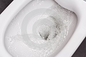 Flush toilet. Water flushes the toilet. The flow of water is clearly visible