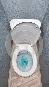 Flushing a toilet with blue water in it.