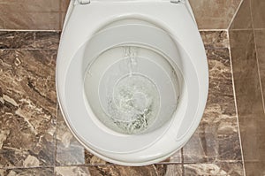 Flushing the toilet. A strong whirlpool of water in the toilet