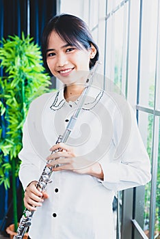 Flute classical instrument profestional player playing song. A young and elegant Asian woman plays the flute