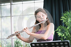 Flute classical instrument profestional player playing song.  A young and elegant Asian woman plays the flute. Vintage Stye