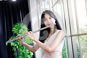 Flute classical instrument profestional player playing song.  A young and elegant Asian woman plays the flute. Vintage Stye