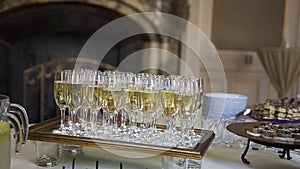 Flute of cold white champagne or sparkling wine standing on the tray at a festive event or celebration