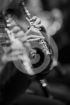 Flute in the hands of a musician in the orchestra closeup