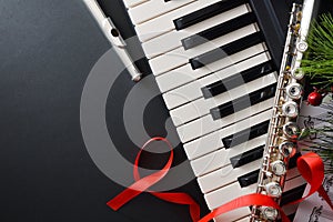 Flute and piano on black table and Christmas decoration