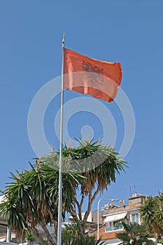 Fluttering Albanian flag blue sky in background