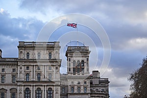 Fluttering Great britain flag in wind on flag pole on roof of the historical building in the London