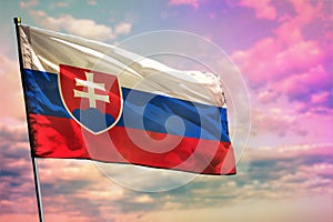 Vlajúca vlajka Slovenska na farebnom pozadí zamračenej oblohy. Koncept prosperity