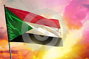 Fluttering Sudan flag on beautiful colorful sunset or sunrise background. Success concept