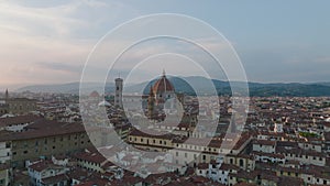 Fly above historic city centre of popular travel destination. Famous sights at dusk. Florence, Italy
