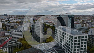 Fly above modern office buildings in urban borough. Revealing wide street with road intersection. Charlottenburg