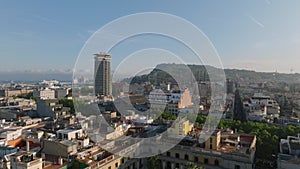 Fly above streets and buildings in old town quarter. Rooftop terraces on palaces around Placa Reial. Barcelona, Spain