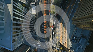 Fly above wide street in modern downtown district with high rise buildings. Top down panning footage. New York City, USA