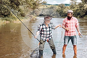 Fly angler on the river. Angler. Family and generation - summer holidays and people concept. Fishermen with fishing rod