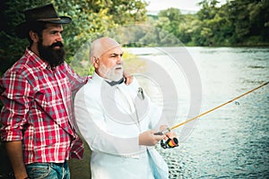 Fly angler on the river. Father and son fishing. Fly fishing for trout. Happy father and son together fishing in summer