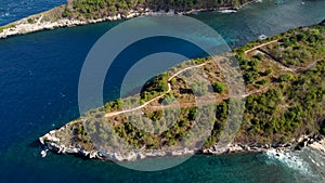 Fly around cliff and rocks over ocean along coast