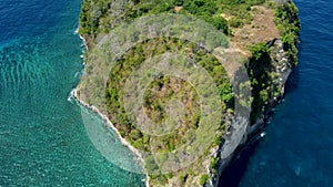 Fly around cliff and rocks over ocean along coast