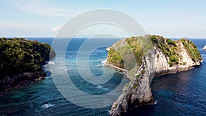 Fly around cliff and rocks over ocean along coast