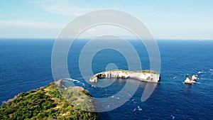 Fly around cliff and rocks over ocean along coast