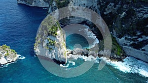 Fly around cliff and rocks over ocean along coast